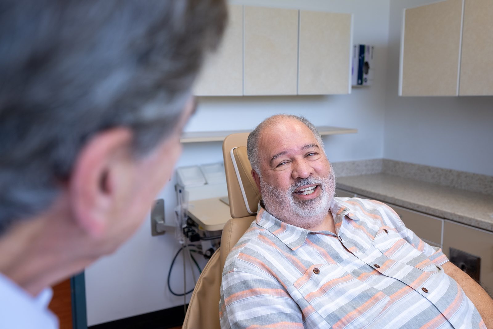 Mature patient receiving a dental implant candidacy assessment showing that age alone does not disqualify implant candidates