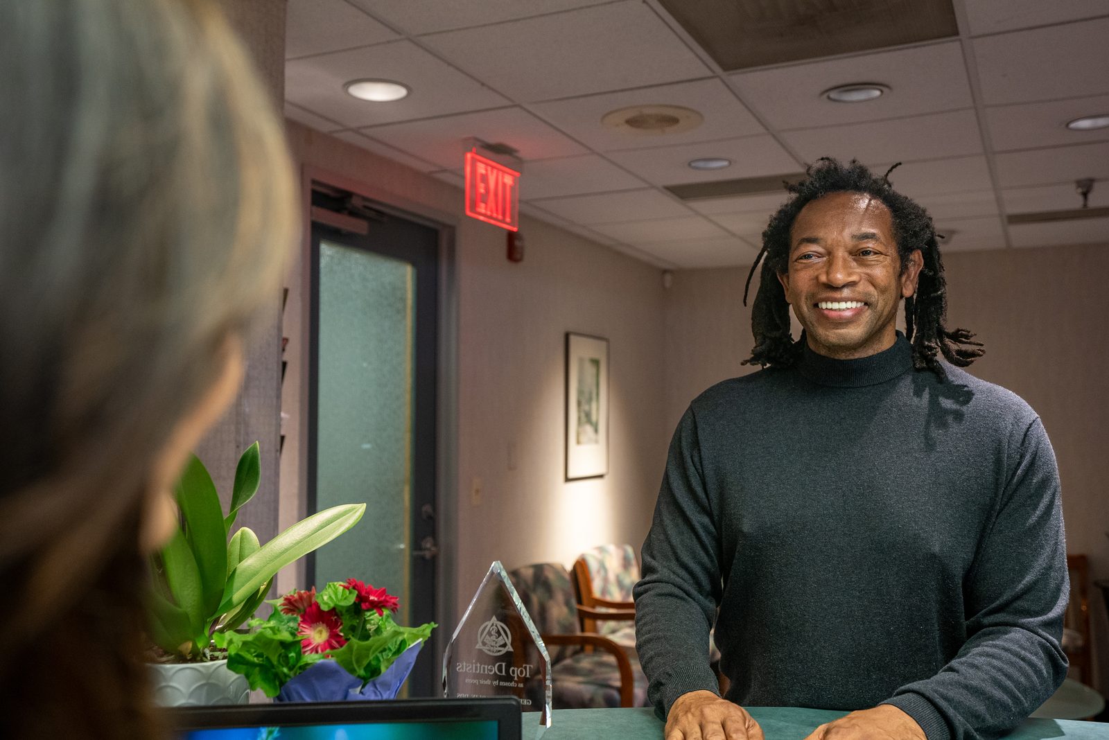 Professional dental implant care team member providing post-operative instructions to a recovering patient