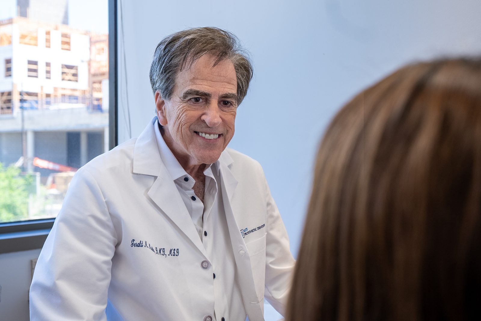 Specialist prosthodontist discussing dental implant treatment options with a Bethesda patient during consultation